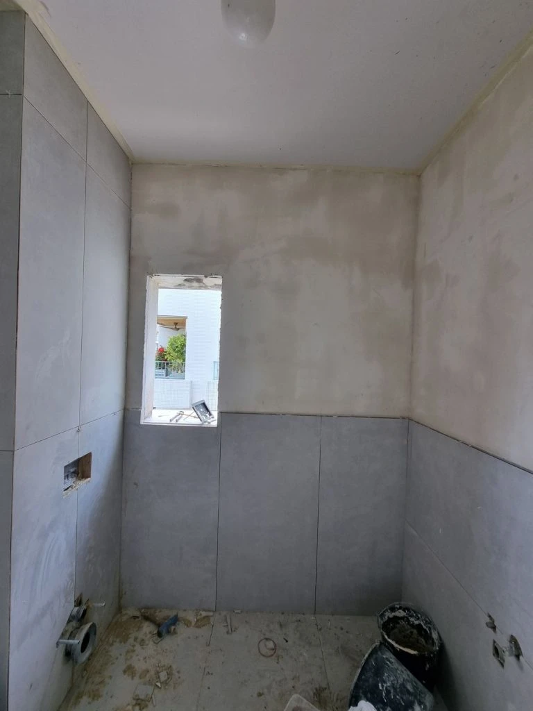 קירות מטויחים לפני התקנת חיפוי במקלחת האורחים