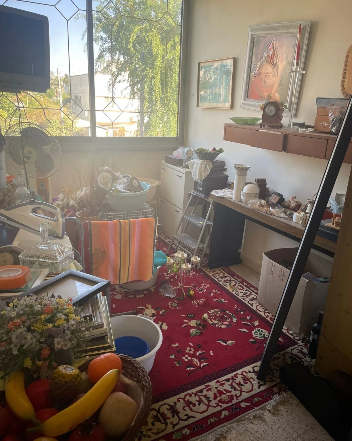חדר אחסון עמוס בחפצים ורהיטים ישנים לפני השיפוץ