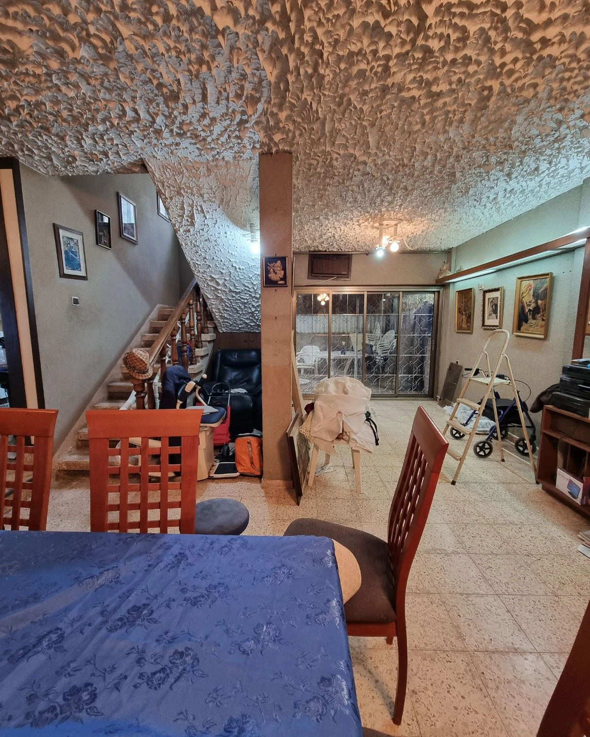 פינת ישיבה ישנה ליד המדרגות עם הליכון רפואי לפני השיפוץ