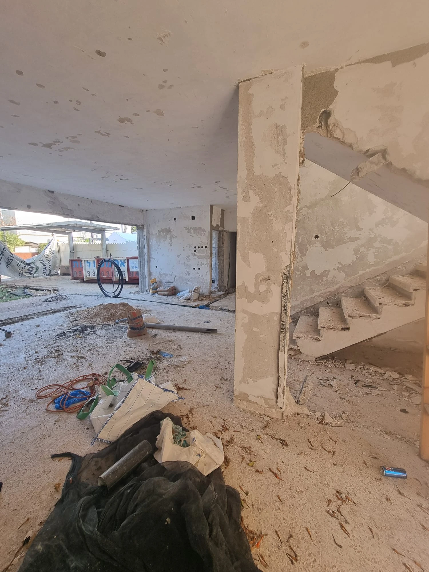 מדרגות בטון חשופות ופתח קיר שנשבר בזמן השיפוץ