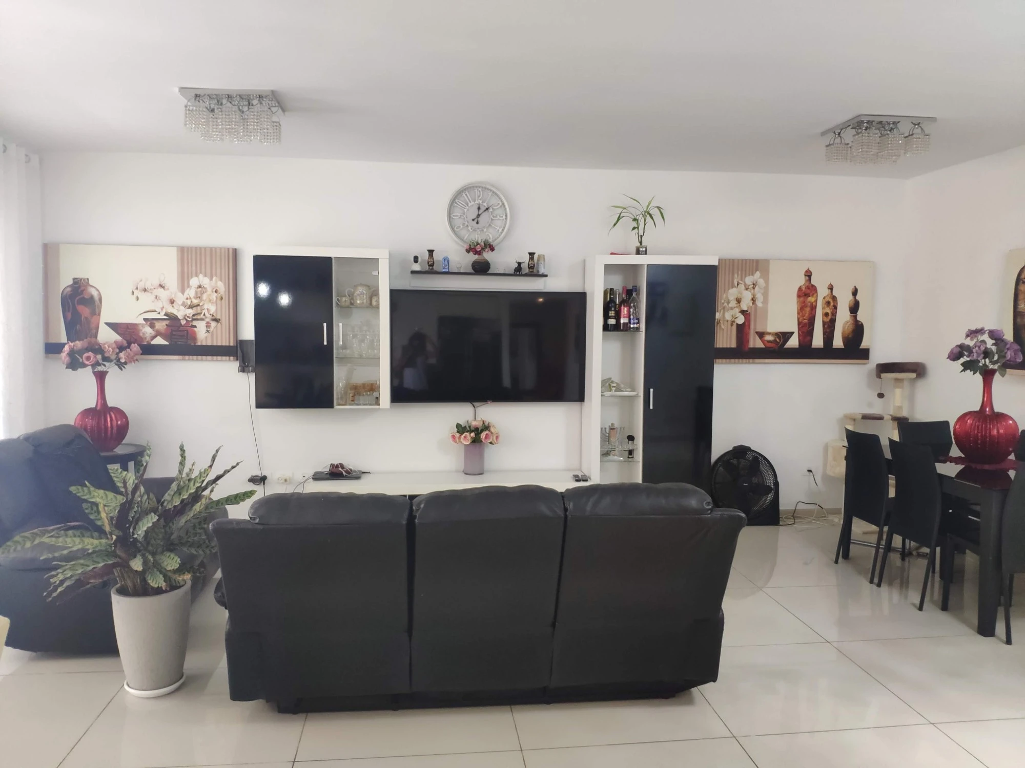 סלון ופינת אוכל לפני השיפוץ, עם מערכת מזנון שחורה-לבנה וספה עור שחורה